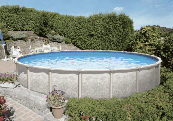 Above-ground PREMIUM POOL - MAGNUS 54" - 7" Resin Top Rail  - SALT FRIENDLY in a garden with stone walls, surrounded by greenery and flowers, sunny day.